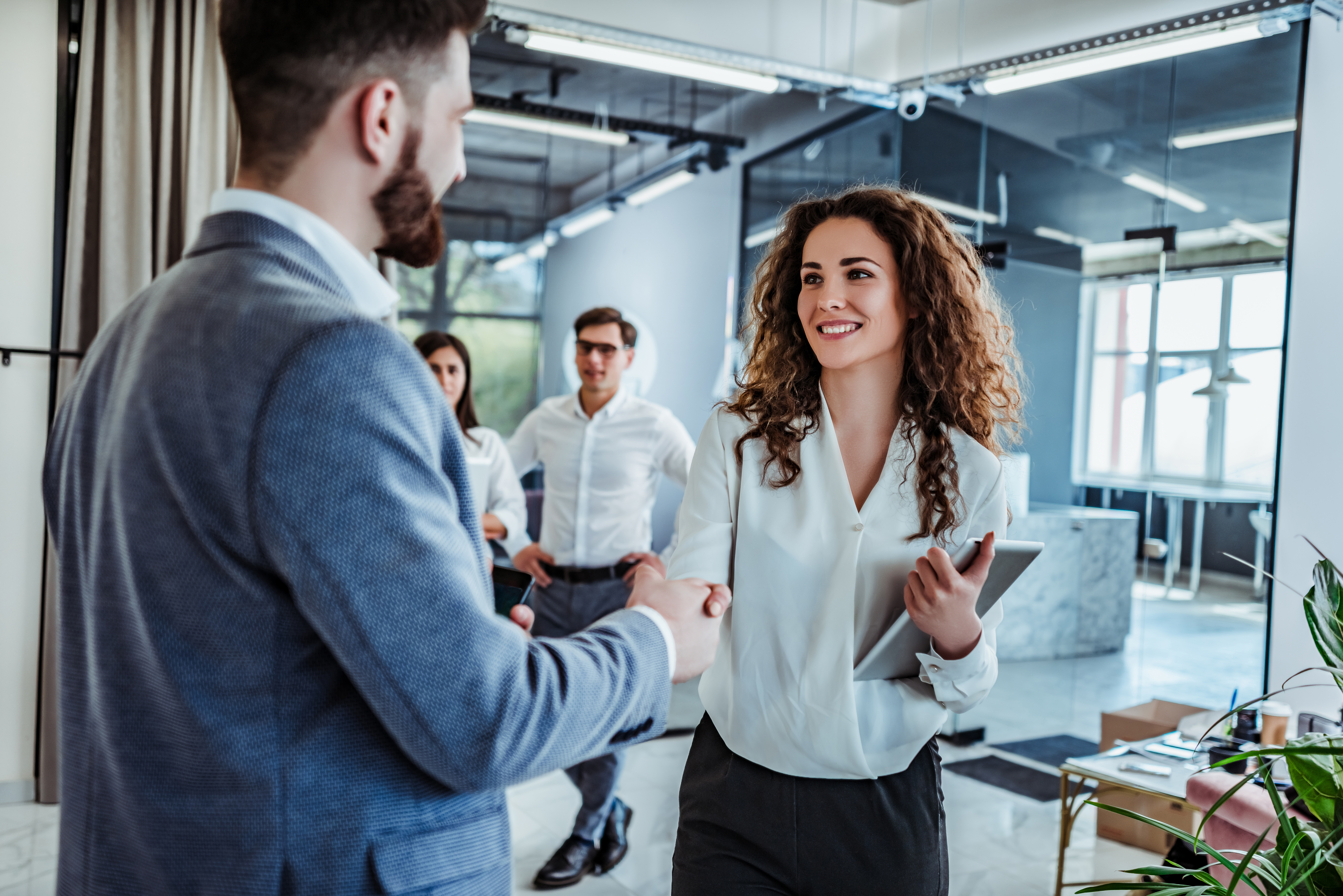 Man and woman are shaking hands in office. Collaborative teamwork.Business professionals