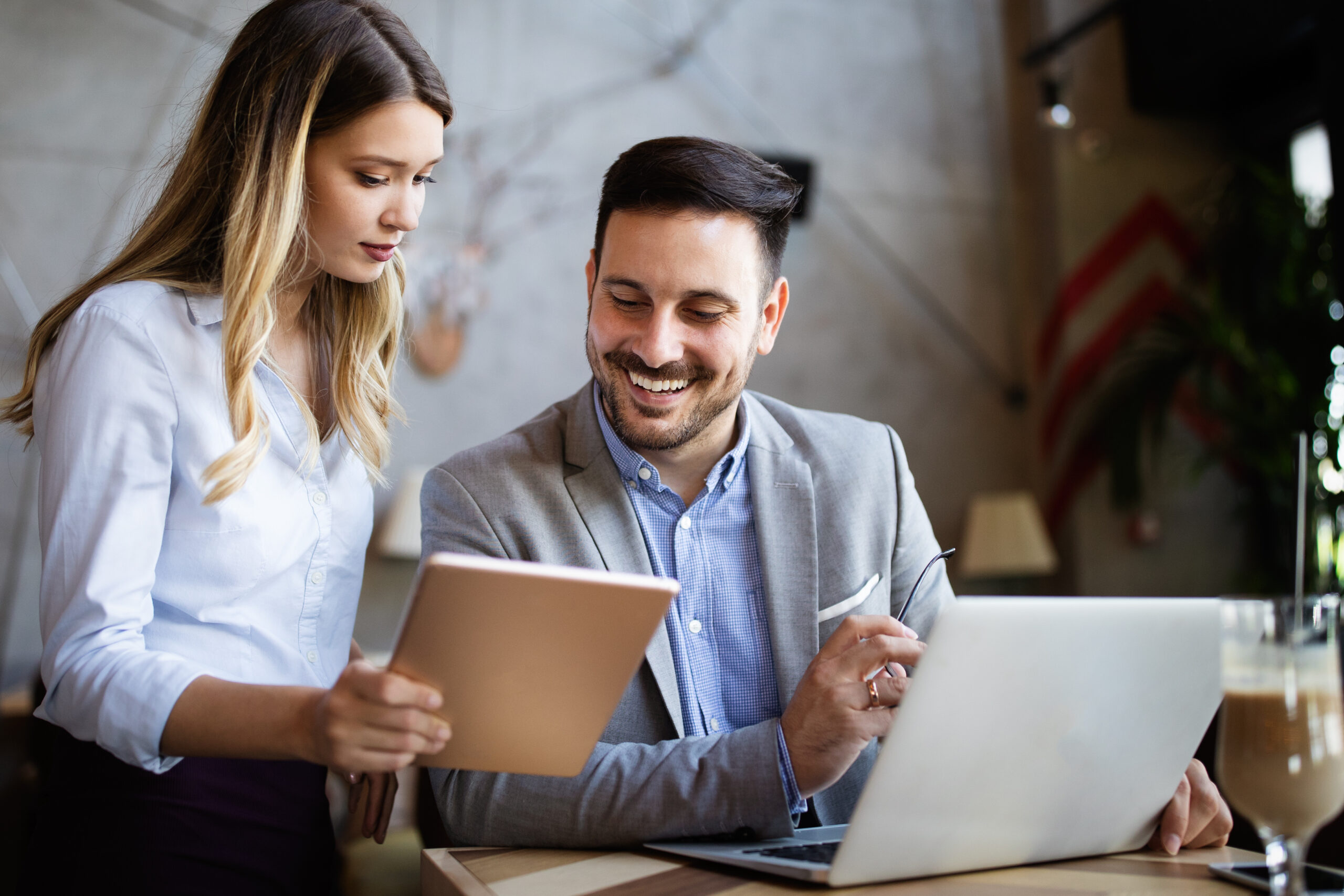 Business colleagues working and laughing while looking at the laptop in office